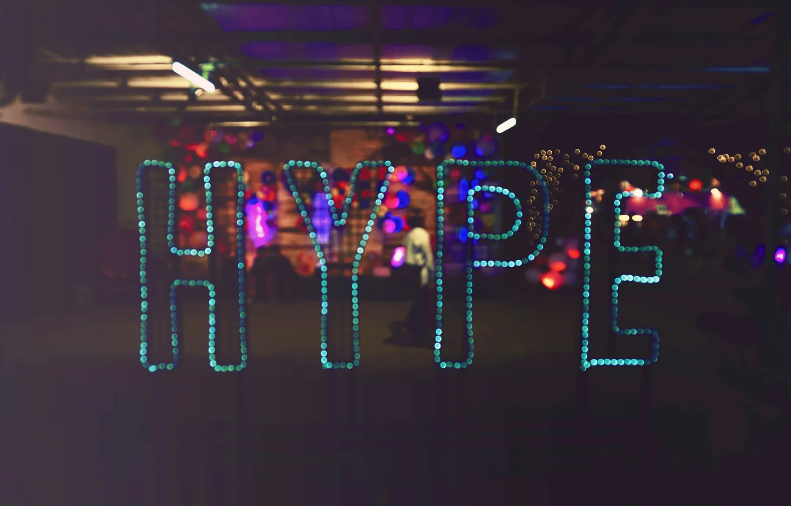 Bunt beleuchteter Schriftzug „HYPE“ in einem dunklen Raum